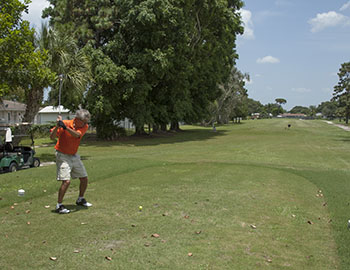 Golfer taking swing on fairway